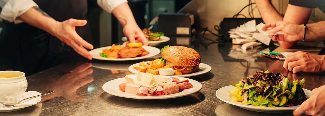 chefs hands with plates of food